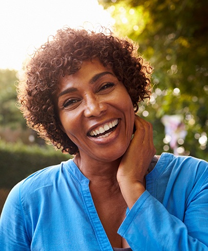 Middle-aged woman smiling after visiting her Altus endodontist in Worcester