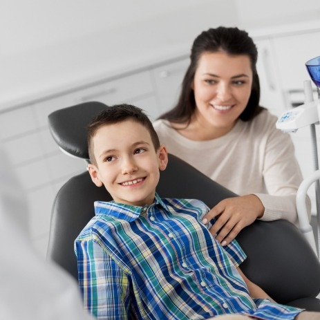 Young child smiling at endodontist after pulpectomy