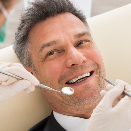 Man smiling during the endodontic retreatment process