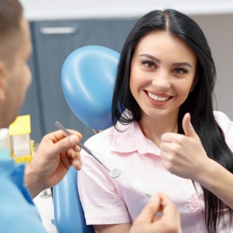 Woman giving thumbs up after Gentle Wave root canal therapy