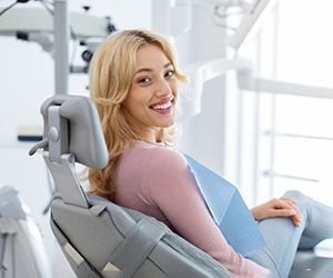 Woman sitting in treatment chair and smiling at camera