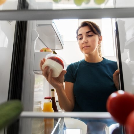 Woman eating yogurt while healing from root canal therapy