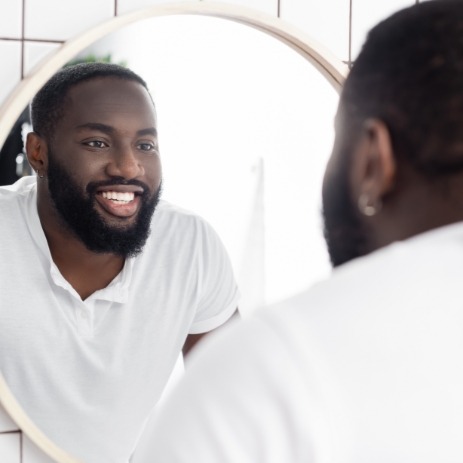 Man looking at smile after endodontic retreatment