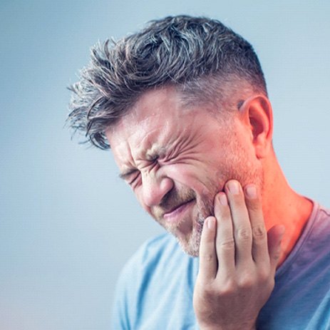 a patient holding their mouth in pain