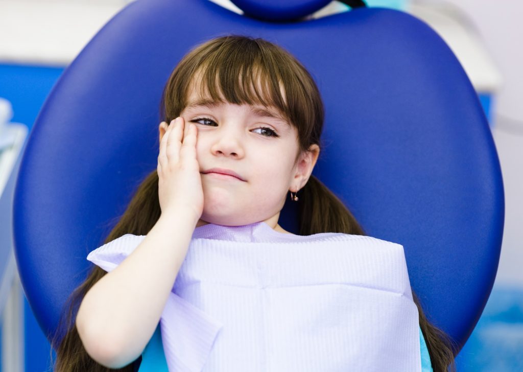 Child with tooth pain visiting dentist