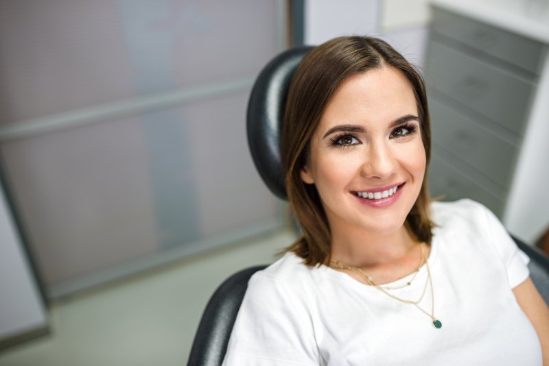 Woman lying back in dental chair and smiling