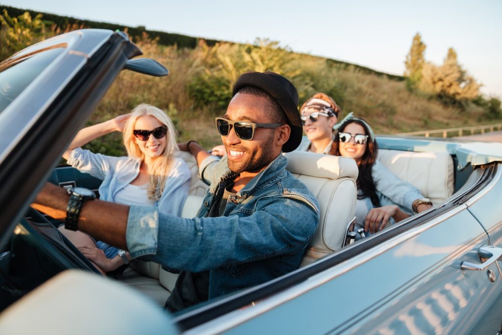 Group of friends smiling on road trip