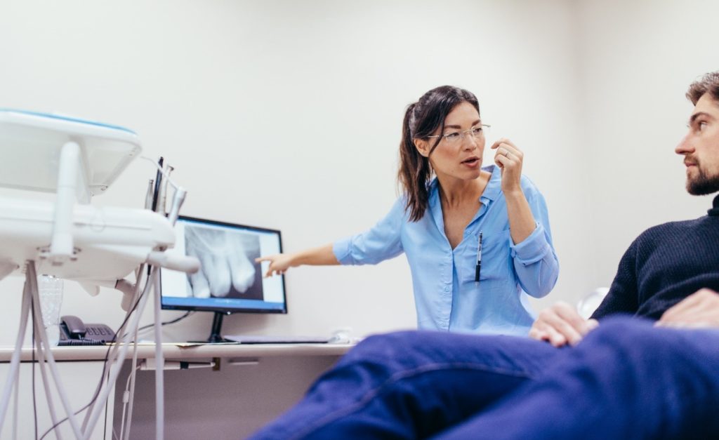 Dentist explaining intentional replantation to patient