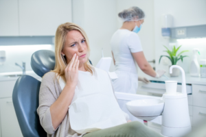 a patient holding their mouth in pain while visiting an endodontist