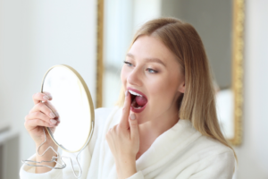 a patient examining their tooth in a mirror